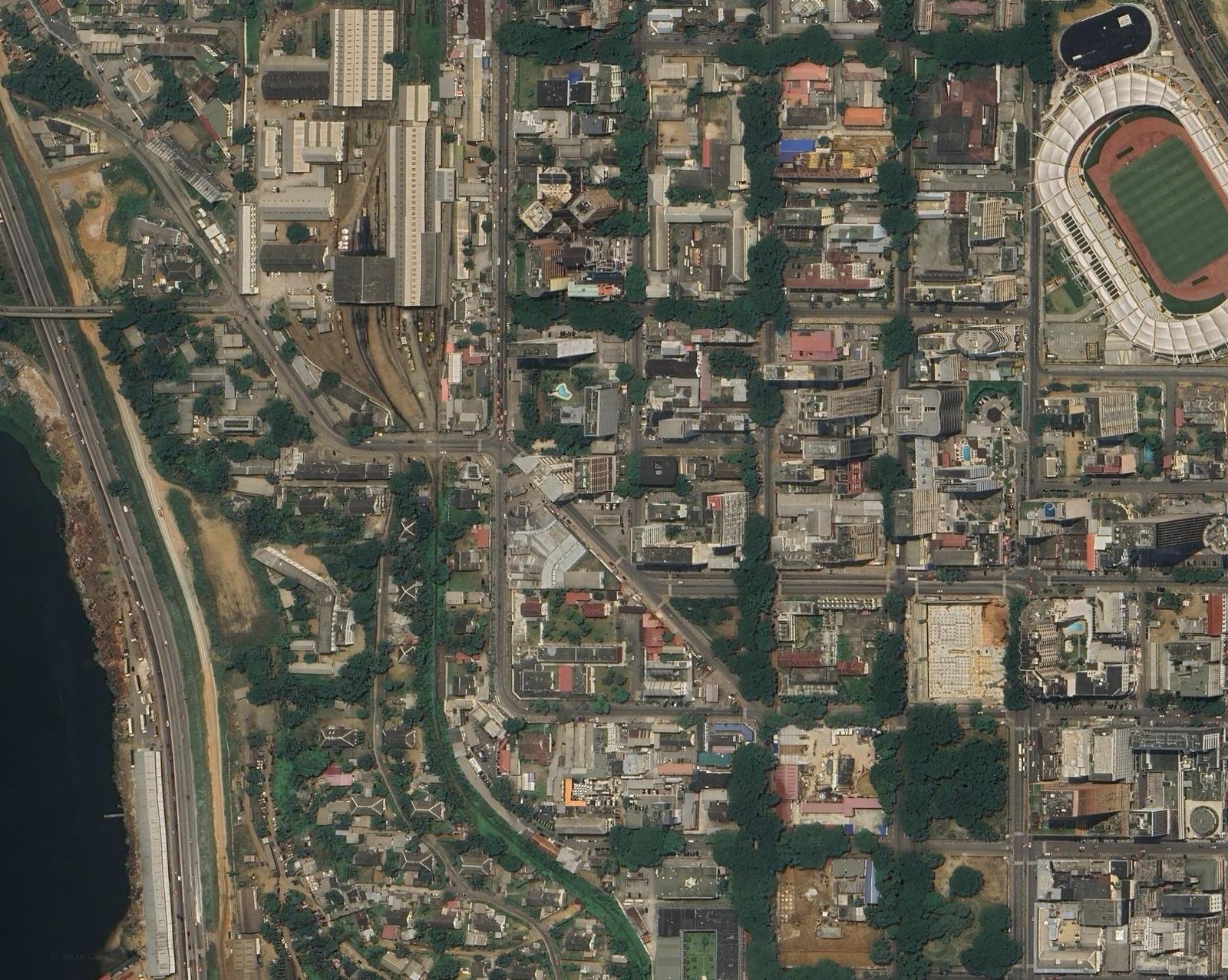 Image satellite réelle du Plateau à Abidjan : lagune, gare ferroviaire, stade et parcs